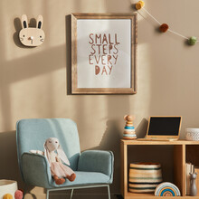 Cozy Interior Of Child Room With Mint Armchair, Brown Mock Up Poster Frame, Toys, Teddy Bear, Plush Animal, Decoration And Hanging Cotton Colorful Balls. Beige Wall. Warm Kid Space.  Template.