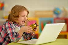 Portrait Of Adorable Little Girl Using Modern Laptop And Playing Game
