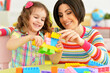 © aletia2011 - Close up portrait of cute little girl and her mother playing colorful plastic blocks together in her room
