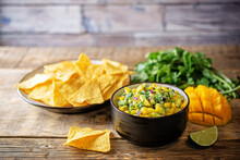 Mango Guacamole With Corn Chips And Ingredients To Prepare It