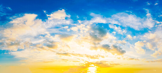 Wall Mural - Sky at sunset blue and orange light of the sun through the clouds in the sky