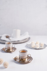 Dos tazas de té clásico con dulces chocolates blancos cubiertos de coco en el cuadro blanco