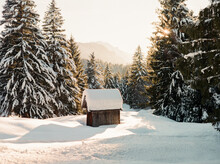 Snow Covered Rustic Cabin In The Woods Of A Winter Wonderland