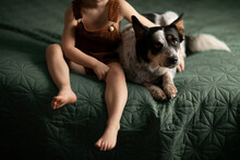 A Boy And His Dog Resting On The Bed