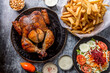grilled chicken served with french fries and salad on gray marble