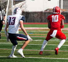 Football Wide Receiver Catching The Ball In Front Of The Defender