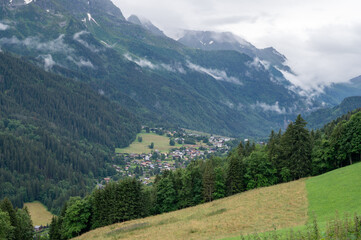 Wall Mural - Panoramic view on mountain villages, green forests and apline meadows near Saint-Gervais-les-Bains, Savoy. France