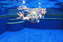 Funny Portrait Of Child Learning Swimming, Dive In Blue Pool With Fun - Jumping Deep Down Underwater With Splashes. Healthy Family Lifestyle, Kids Water Sports Activity, Swimming Lesson With Parents.