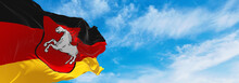 Flag Of Lower Saxony At Cloudy Sky Background On Sunset, Panoramic View. Federal Republic Of Germany. Copy Space For Wide Banner