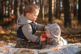 Fototapeta Dinusie - A two-year-old boy feeds his younger brother an apple.
