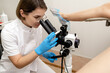 © Tatyana - A gynecologist examines a patient sitting on a gynecological chair using a colposcope.Women's health, medical concept.Selective focus,side view.