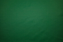 Green Football Jersey Clothing Fabric Texture Sports Wear Background, Close Up. Sport Clothing Fabric Texture Background. Top View Of Cloth Textile Surface. Green Football Shirt. 