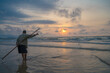 Fisherman casting his net at the sunrise or sunset. Traditional fishermen prepare the fishing net