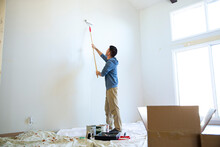 Young Man Painting Wall At Home