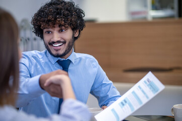 Curly-haired indian young man looking surprised