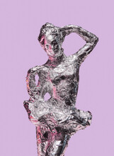 Female Statuette Ballerina Wrapped In Tinfoil On Pink Background. Trendy Minimalist Fashion.
