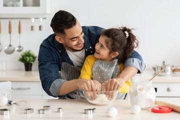 Wall Mural - Father Daughter Leisure. Happy Arab Dad Baking With Female Child In Kitchen