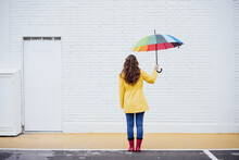 Woman Holding Multi Colored Umbrella On Footpath
