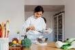 © Westend61 - Smiling chef preparing food in kitchen at home