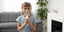 Little Girl Making Inhalation With Nebulizer At Home. Child Asthma Inhaler Inhalation Nebulizer Steam Sick Cough Concept.
