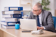 © Elnur - Old male employee unhappy with excessive work in the office