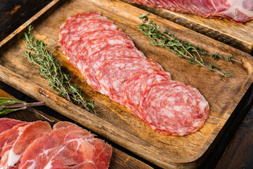 Wall Mural - Meat antipasto, pancetta, salami, sliced ham prosciutto, on old dark  wooden table background