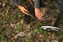 A Man With An Electronic Metal Detector In The Forest. Outdoor Searches. Close-up. A Man With A Shovel.
