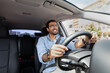 © Prostock-studio - Joyful middle-eastern man driving car, shot from front pannel