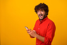 Funny surprised trendy guy suddenly read message on his mobile phone and expressing shock amazement, unbelievable news on smartphone. Studio shot isolated