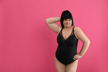 Wall Mural - Beautiful overweight woman in black underwear on pink background, space for text. Plus-size model