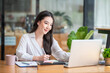 © amnaj - Portrait of young Asian businesswoman sitting taking notes in the office.