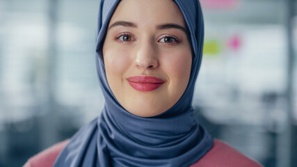 Sticker - Close-up Portrait of Muslim Businesswoman Wearing Hijab Looks at Camera and Smiles. Beautiful Woman Wearing Traditional Headscarf. Successful Empowered Arab Woman.