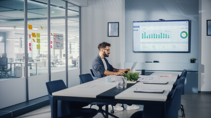 Leinwandbilder - Office Conference Meeting Room: Handsome Hispanic Specialist Working on Laptop Computer with Big Wall TV with Big Data Analysis, Charts and Infographics. Businessperson Working in Growing Startup.