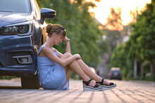 Young Woman Driver Sitting Beside Her Broken Car Waiting For Help. Vehicle Problems Concept