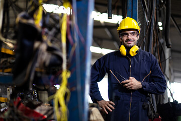 Portrait of factory worker and engineer at industrial facility. Construction worker in hardhat and Walkie-talkie or Two Way Radio in hand