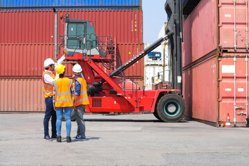 Wall Mural - Group of professional dock worker and engineering people wearing hardhat safety helmet and vest working at container yard port of import export. Business teamwork concept