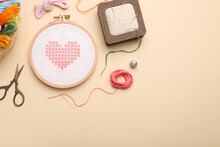 Flat Lay Composition With Embroidery And Different Sewing Accessories On Beige Background. Space For Text
