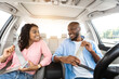 © Prostock-studio - Happy African American Couple Putting On Seatbelts