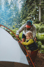 Child Helps Father To Set Camping Tent Travel Family Vacations Hiking Outdoor Adventure Lifestyle Backpacking Trip In Forest