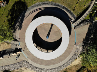 Round gazebo with hole in center in the park with shade from the sun. Urbanism. Public space. Aerial drone view. Flying over. View from top down.