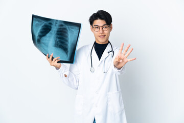 Wall Mural - Young Chinese doctor man holding radiography isolated on white background happy and counting four with fingers