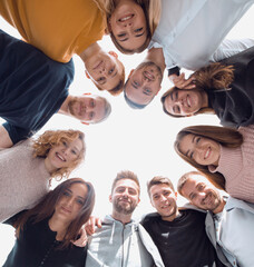 happy young people standing in a circle and looking at the camer