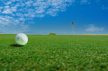 Golf Ball On The Green Course. Sport Playground For Golf Club With Landscape As Background