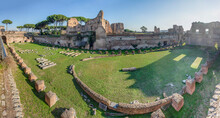 Wide Angle Panoramic View Of The Garden Or "stadium" Of The Palace Of Domitian On Palatine Hill In Rome, Italy. Blue Sky, Brick And Marble Ruined Walls, Green Grass, Long Winter Shadows