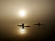 © Amos Chapple/Stocksy - Two kayakers training on a still, foggy morning.
