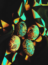 Custom, Colorful And Vibrant DIY Easter Eggs Surrounded With The Dark, Contrasty Rainbow Dotted Fabric Background With Copyspace