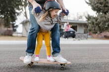 Adorable Little Girl On Skateboard With Dad