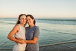 © Kelsey Smith/Stocksy - Happy female couple hugging at the ocean