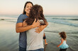 © Kelsey Smith/Stocksy - Same-sex couple hugging at the ocean