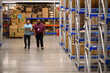 © Raymond Forbes LLC/Stocksy - Two workers with laptop computer at warehouse